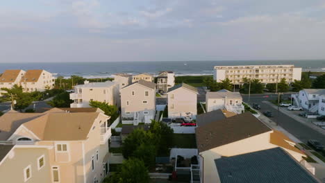 aerial view low over sunlit neighborhood homes, in sunny brigantine, new jersey