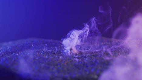 video of hand raising from grass with smoke on black background