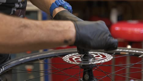 Primer-Plano-De-Un-Mecánico-De-Bicicletas-Macho-Apretando-Los-Tornillos-Del-Freno-De-Disco