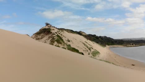 a fast moving forward aerial of a river mouth system and moving over the sand dunes to reveal the ocean