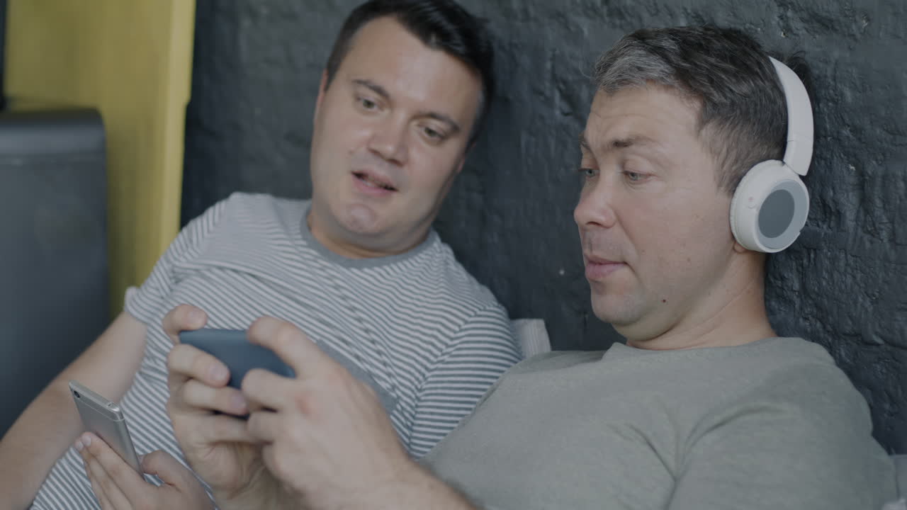 To mænd slapper af og ser på en telefon sammen