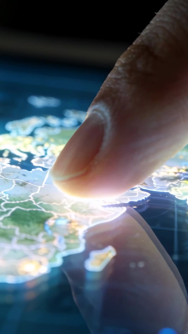 Video verticale: Dito adulto che tocca e trascina verso ovest su un tablet, rivelando una mappa del mondo luminosa.