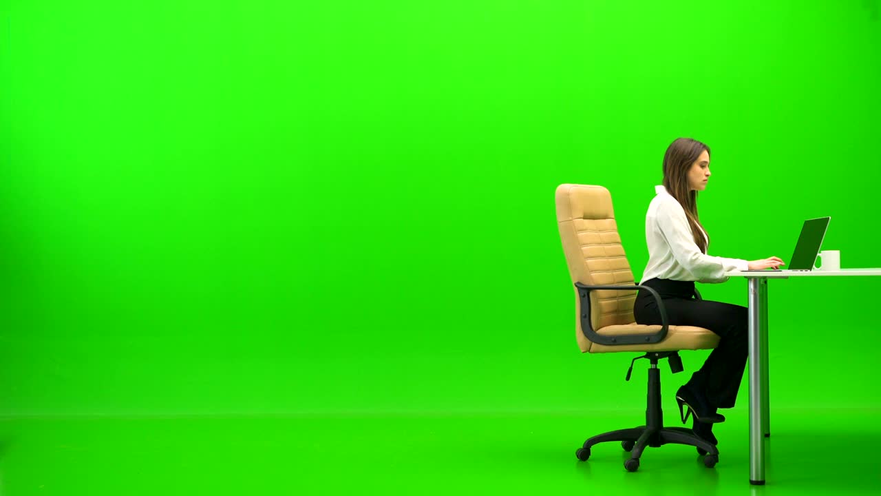 la mujer de negocios trabajando con una computadora portátil en la mesa sobre el fondo verde