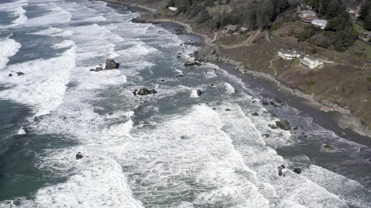 increíble vista aérea hacia adelante sobre las olas del océano rompiendo en la costa rocosa, brookings