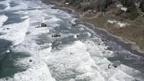 Increíble-Vista-Aérea-Hacia-Adelante-Sobre-Las-Olas-Del-Océano-Rompiendo-En-La-Costa-Rocosa,-Brookings