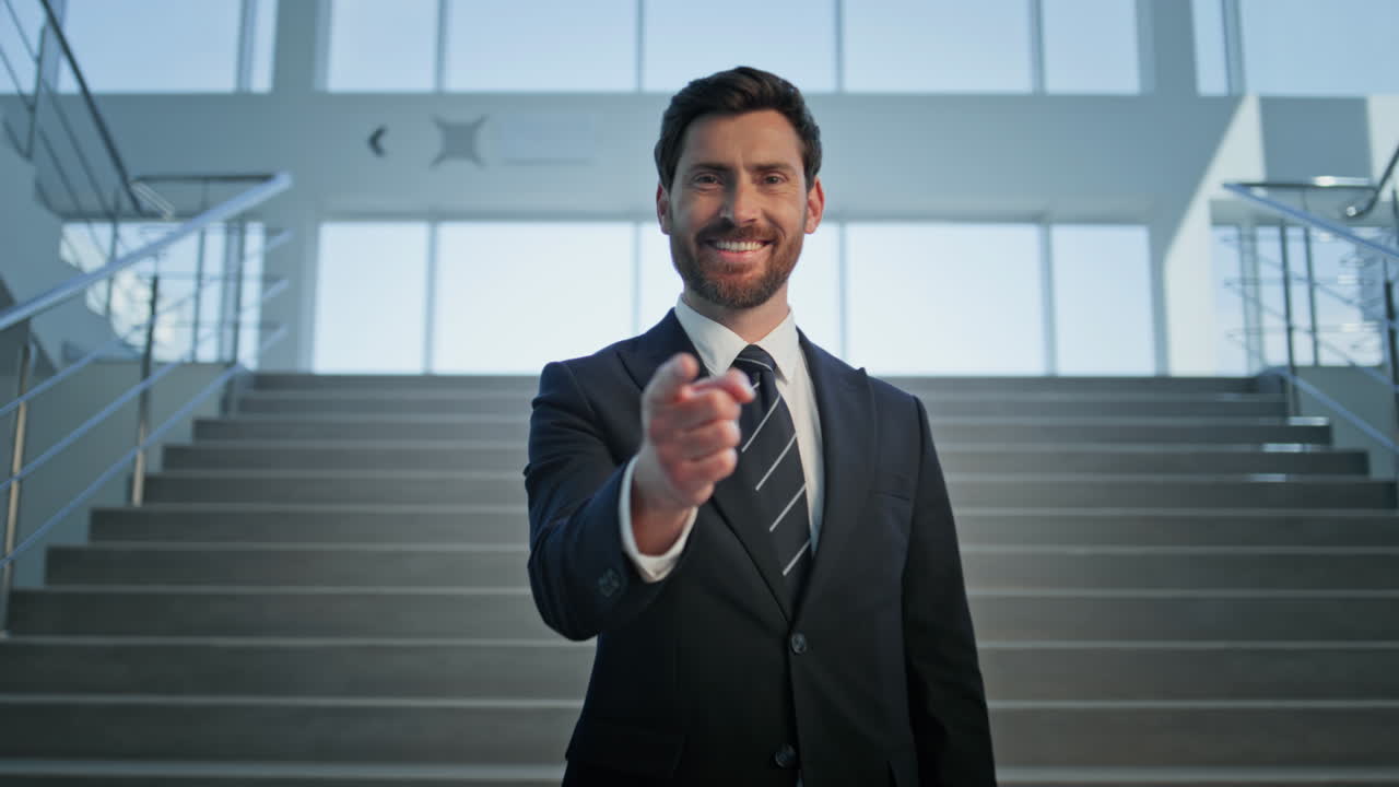 Friendly director posing office staircase pointing finger to camera closeup