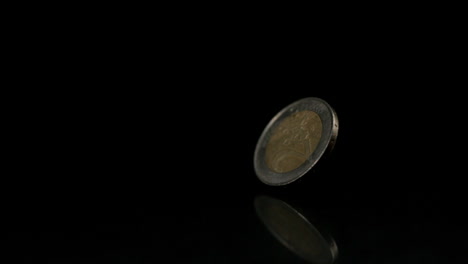 moneda de euro que gira sobre una superficie negra