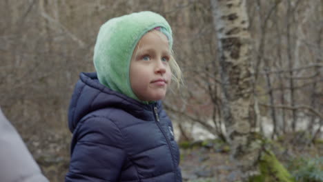 una niña jugando en el bosque de invierno