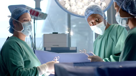 Diverse-female-and-male-surgeons-in-masks-passing-surgical-tools-during-operation,-slow-motion