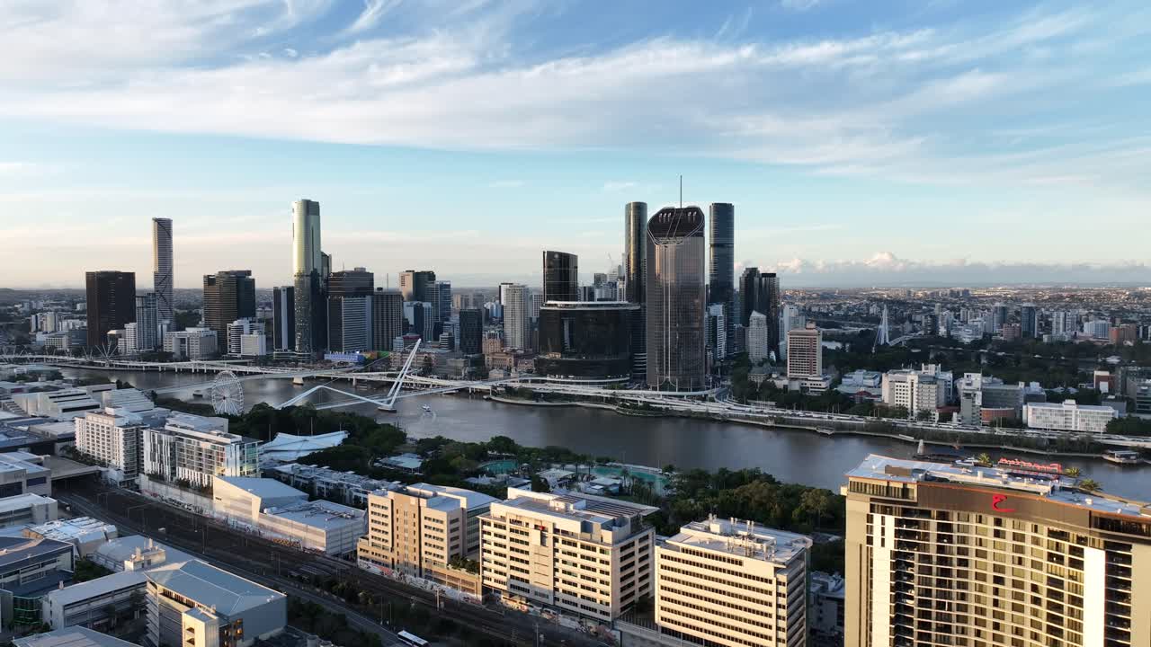 Langsom dronepanorering mod venstre ved gylden time over Brisbane River, der fokuserer på Queens Wharf og The Star Brisbane-tårnene sammen med Neville Bonner Bridge og CBD-skyline, Brisbane, QLD, Australien.
