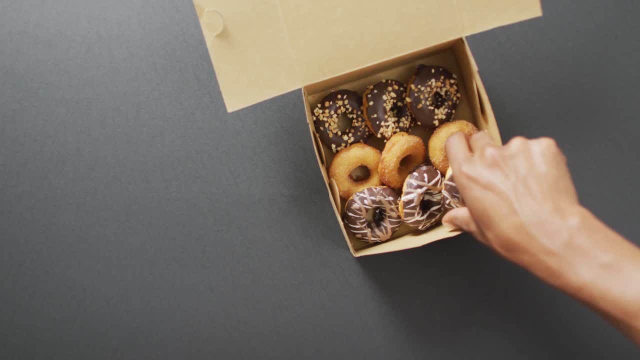 video de rosquillas con chocolate en una caja sobre un fondo gris