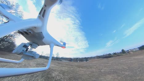 close-up side view of dji phantom 4 quadcopter drone flying over fields