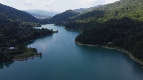 aerial shot of a beautiful and clean ecosystem of lakes and forests at sunset on a cloudy day in paltinu of doftana valley in romania