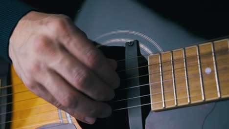 el músico conecta la toma con la salida y toca la guitarra acústica