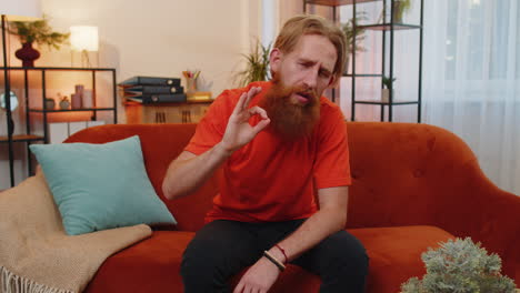 happy cheerful bearded man looking approvingly at camera showing ok gesture, positive like sign