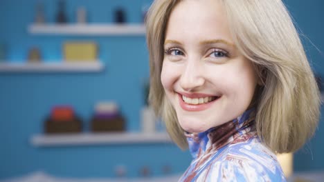 the woman looks back at the camera and laughs. blonde and young woman.