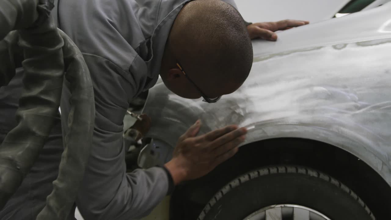아프리카계 미국인 남성 자동차 메카닉 이 자동차 의  ⁇  을 보고 문지르고 있다