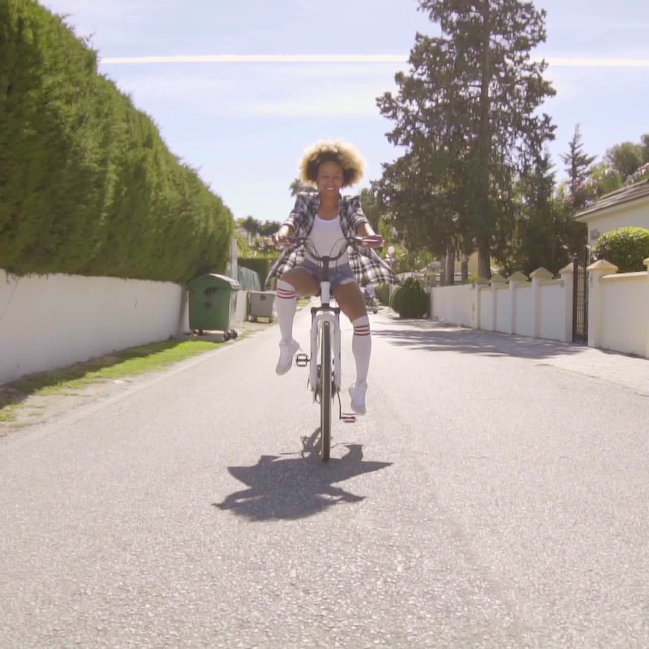 девушка едет с вытянутыми ногами на велосипеде