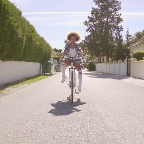 girl riding with feet out on a bicycle