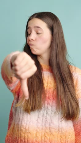 expressive woman giving thumbs down with displeased look