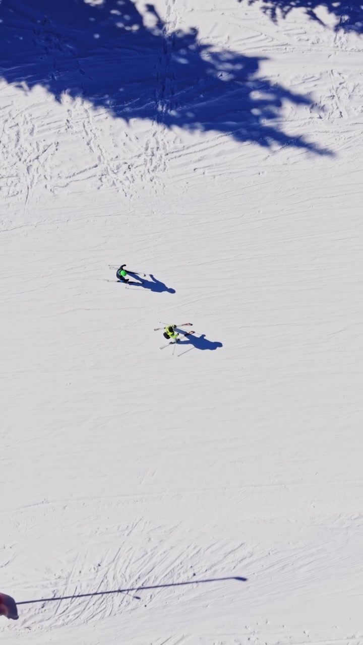 Skiers navigate snowy slopes in the Carpathians of Bulgaria on a sunny day