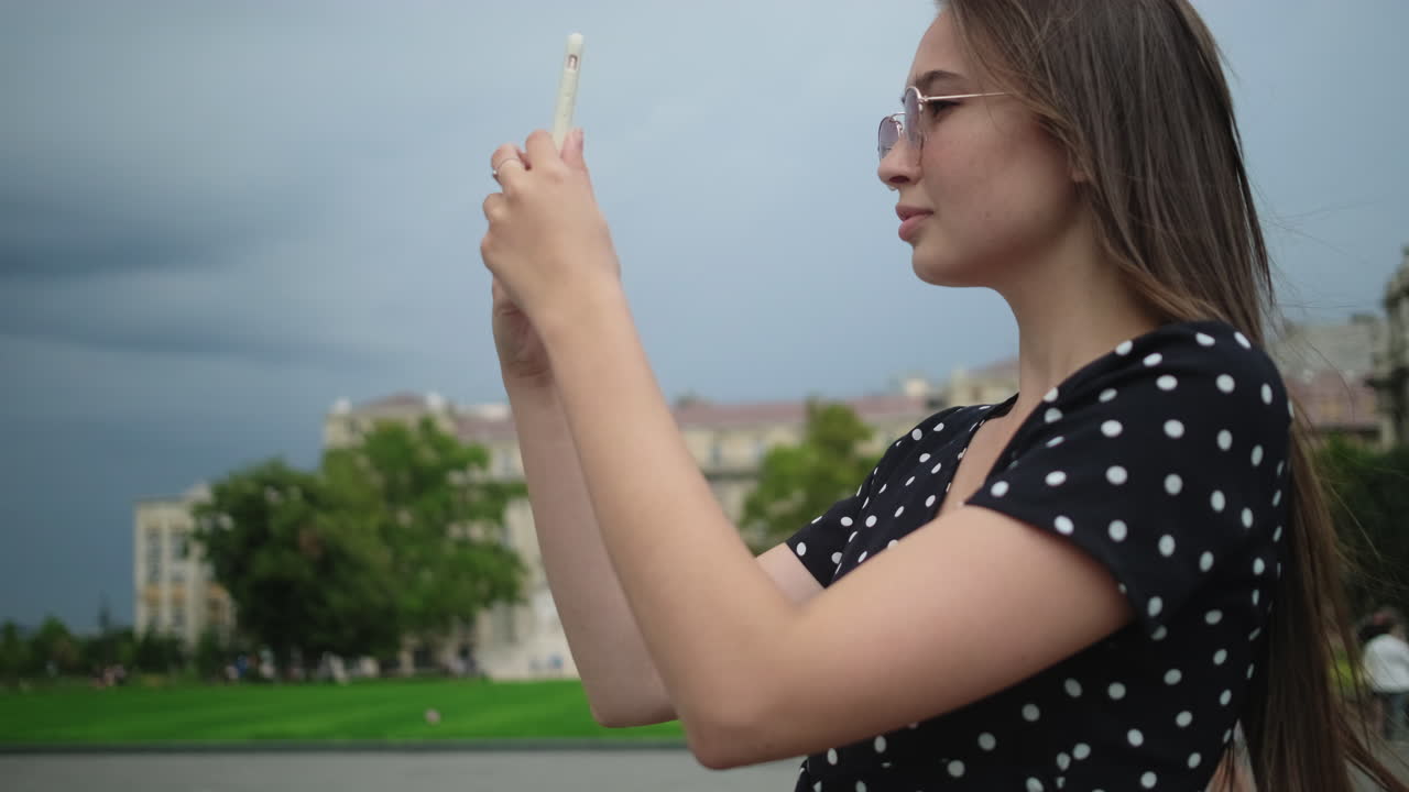 mujer tomando una foto con un teléfono inteligente en una ciudad