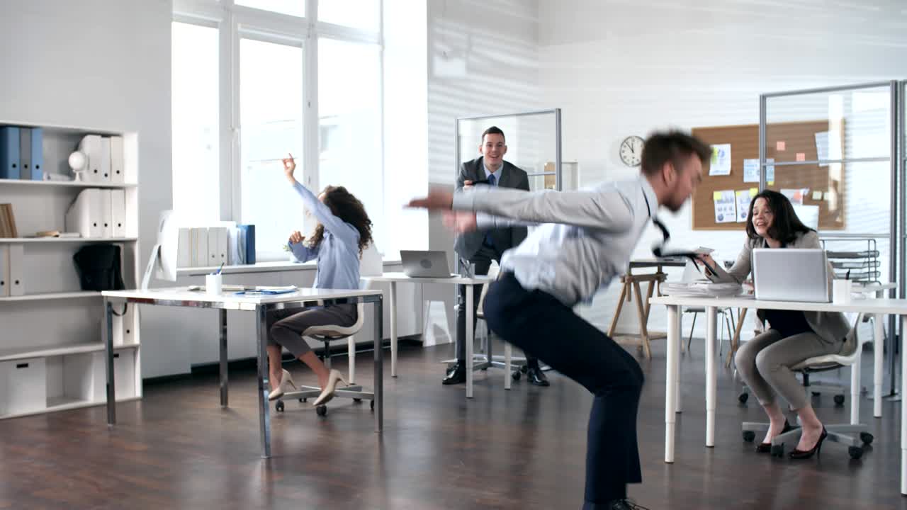 Uomo d'affari energico che balla ed esegue acrobazie in ufficio