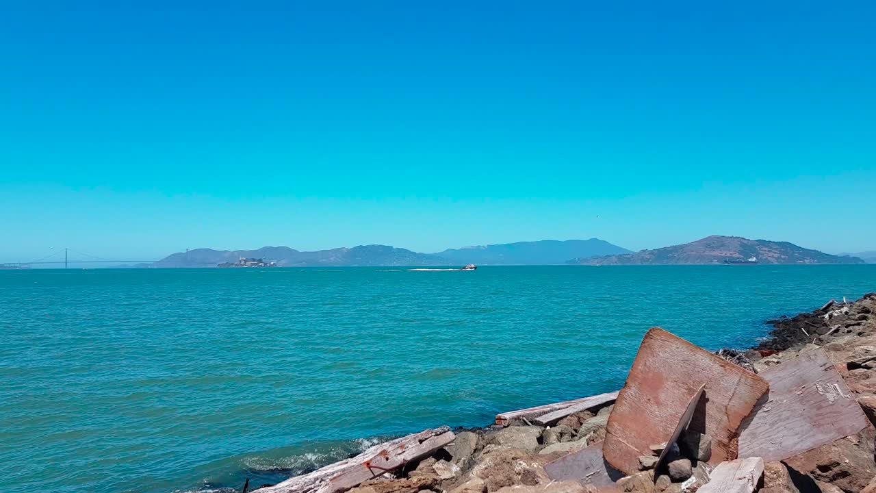 Panorama shot from coast of Treasure Island showing Alcatraz Island, Golden Gate Bridge, San Francisco and the Bay Bridge on a beautiful summer day in California, United States