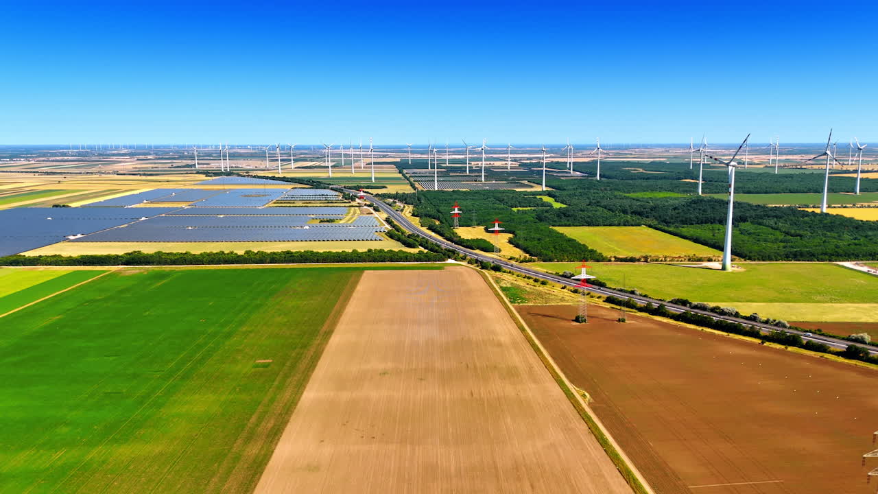 Renewables in the countryside. Aerial view of fields with wind turbines and solar panels, highlighting rural sustainable energy practices