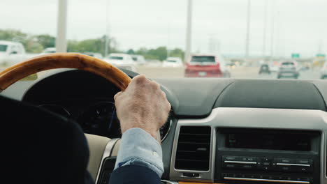 manos de un hombre de negocios en el volante de un coche de lujo