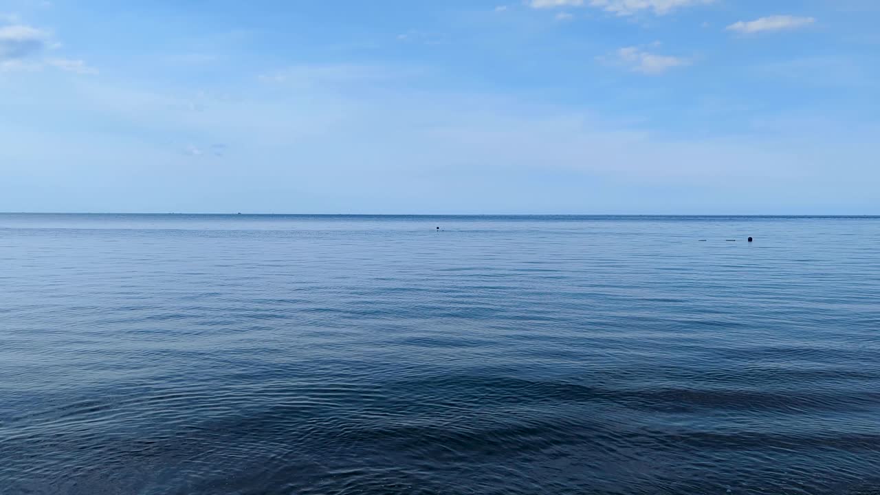 A person snorkeling on the horizon in ocean at Amed on tropical island of Bali Indonesia