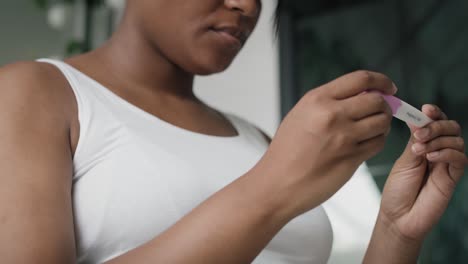 Low-angle-view-of-African-American-stressed-woman--waiting-for-pregnancy-test-results.