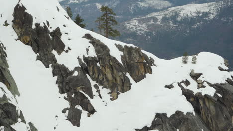 snow covered granite cliffs from dewey point in yosemite national park on a stormy day