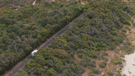 autocaravana conduciendo a lo largo de la carretera costera rastreada por un avión no tripulado