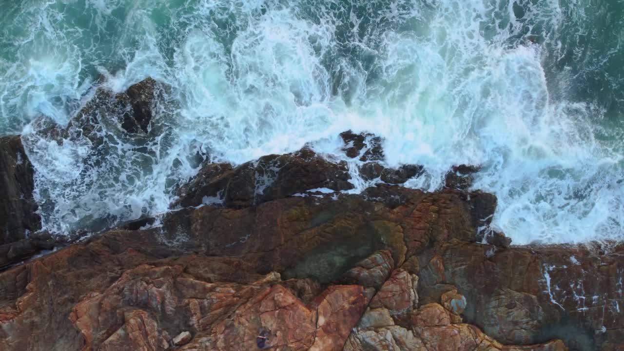 Veduta aerea del paesaggio (ripresa con drone) di onde marine che si infrangono contro le rocce a Khao Laem Ya, Rayong, Thailandia.