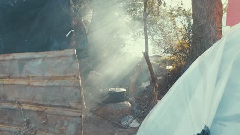 Refugee-camp-pot-cooking-light-beams-smoke