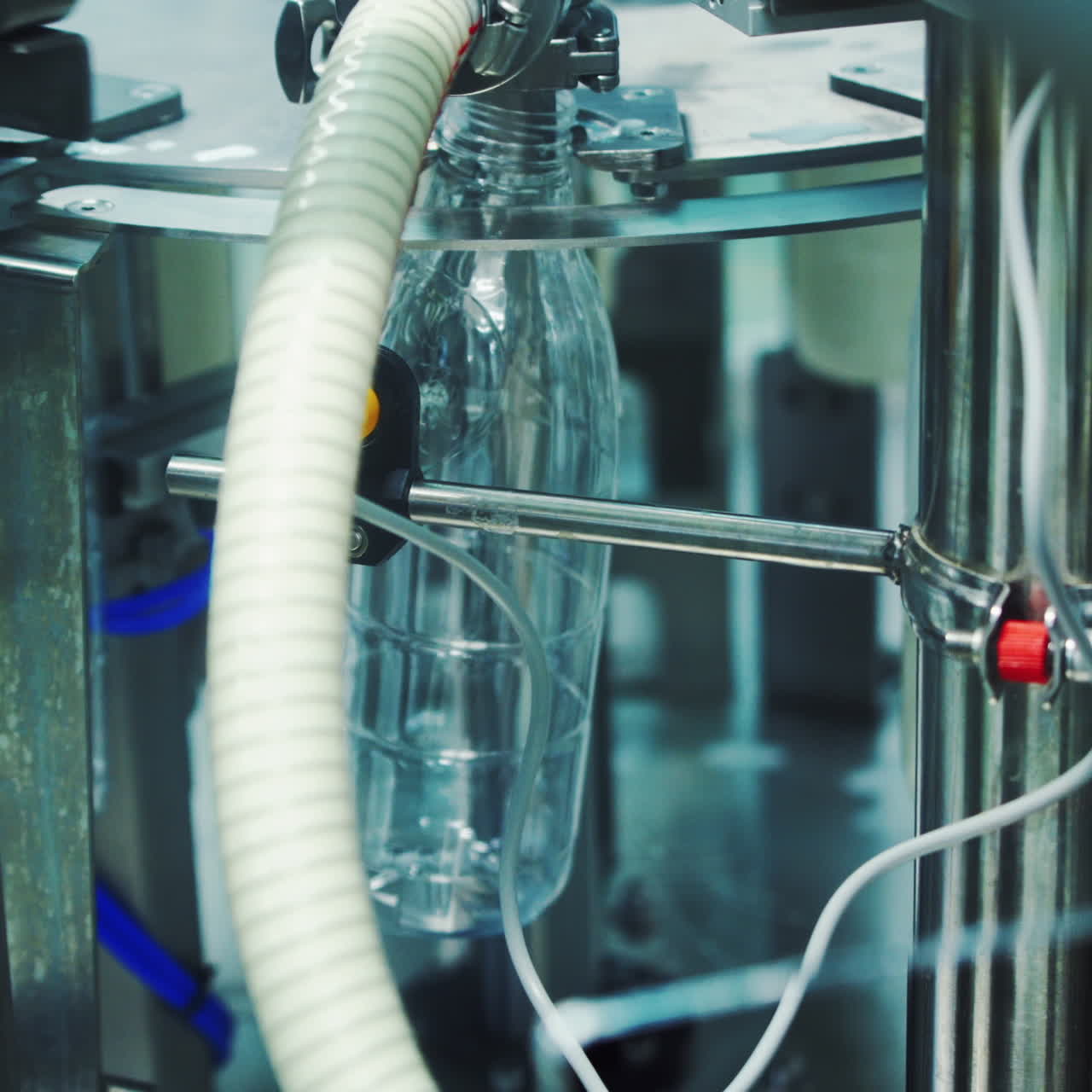 Close-up process of pouring milk into plastic bottle. Robotic machine for bottling milk in a dairy factory.