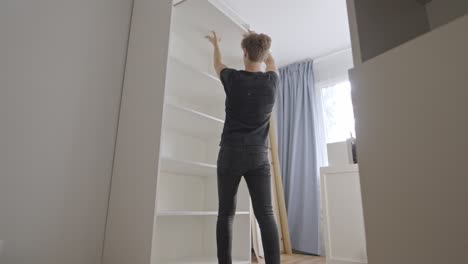 hands-on cabinet assembly inside a pristine white closet