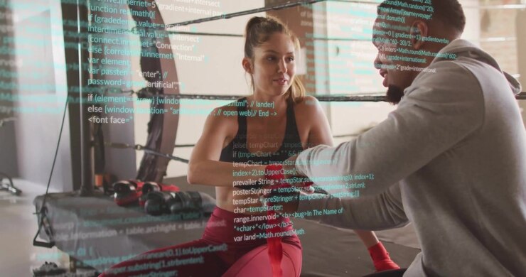 Trainer unrolling red hand wrap spiraling around athlete wrist in boxing gym preparing for sparring