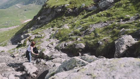 a young woman hiker climbs mountains with photo camera. transfagarasan, carpathian mountains in romania