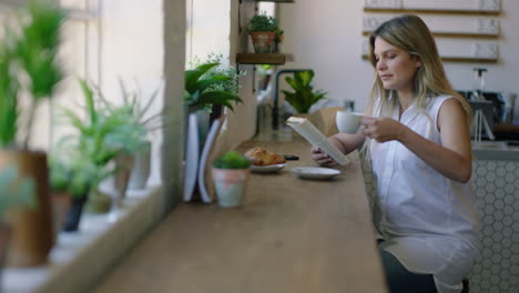 Schöne-Frau,-Die-Im-Café-Ein-Buch-Liest,-Kaffee-Trinkt-Und-Ein-Entspanntes-Morgenfrühstück-In-Einem-Trendigen-Restaurant-Genießt,-Das-Glücklich-Lächelt