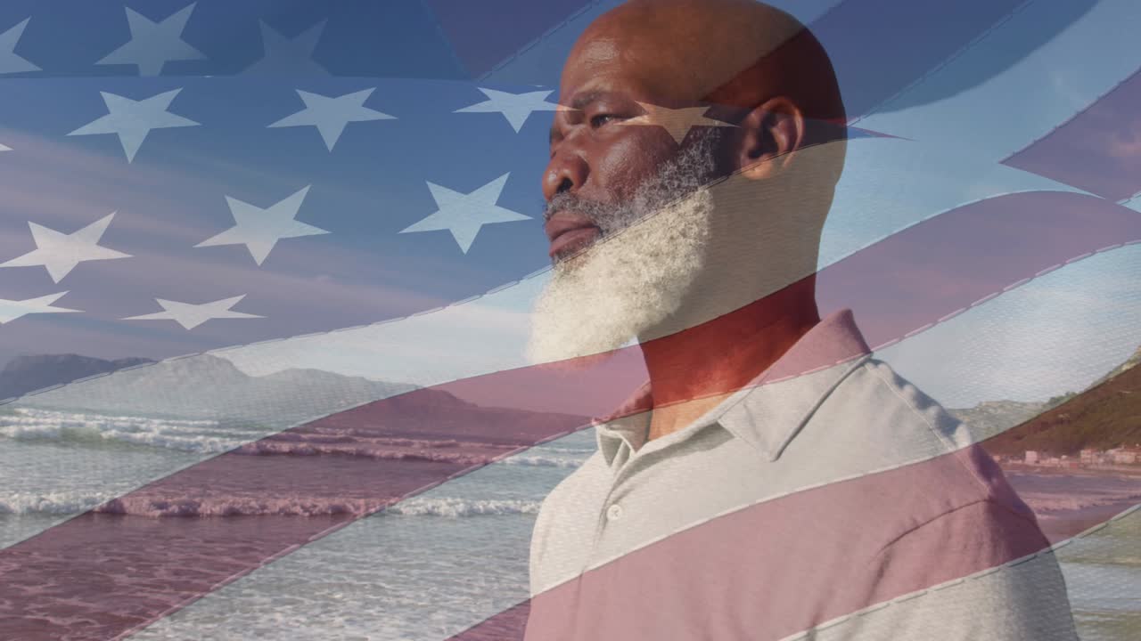 Animation of flag of united states of america over senior african american man on beach