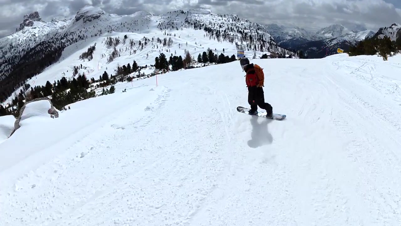 Snowboarder Riding Down a Scenic Mountain Slope in the Dolomites