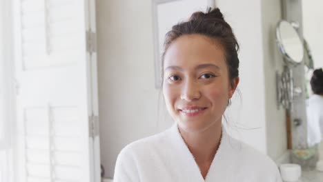 retrato de una feliz mujer asiática sonriendo en el baño, en cámara lenta