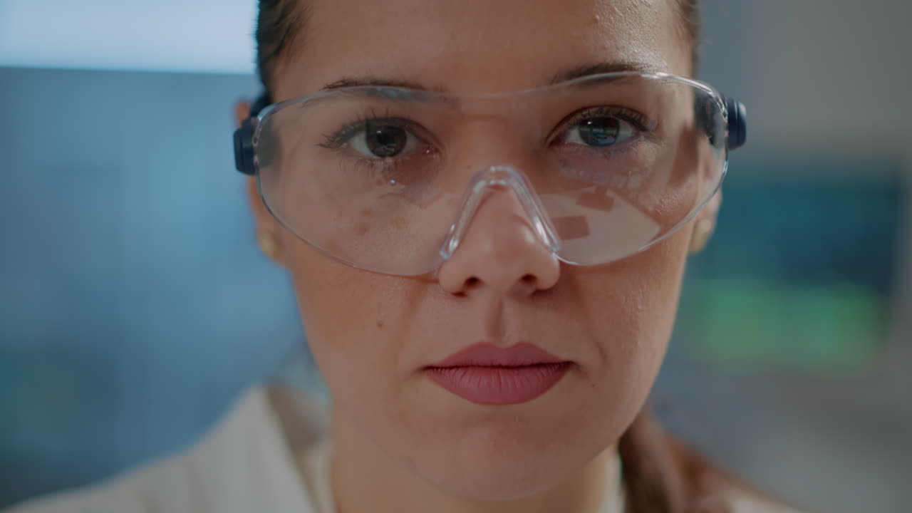 Biochemist with safety goggles and white coat in laboratory
