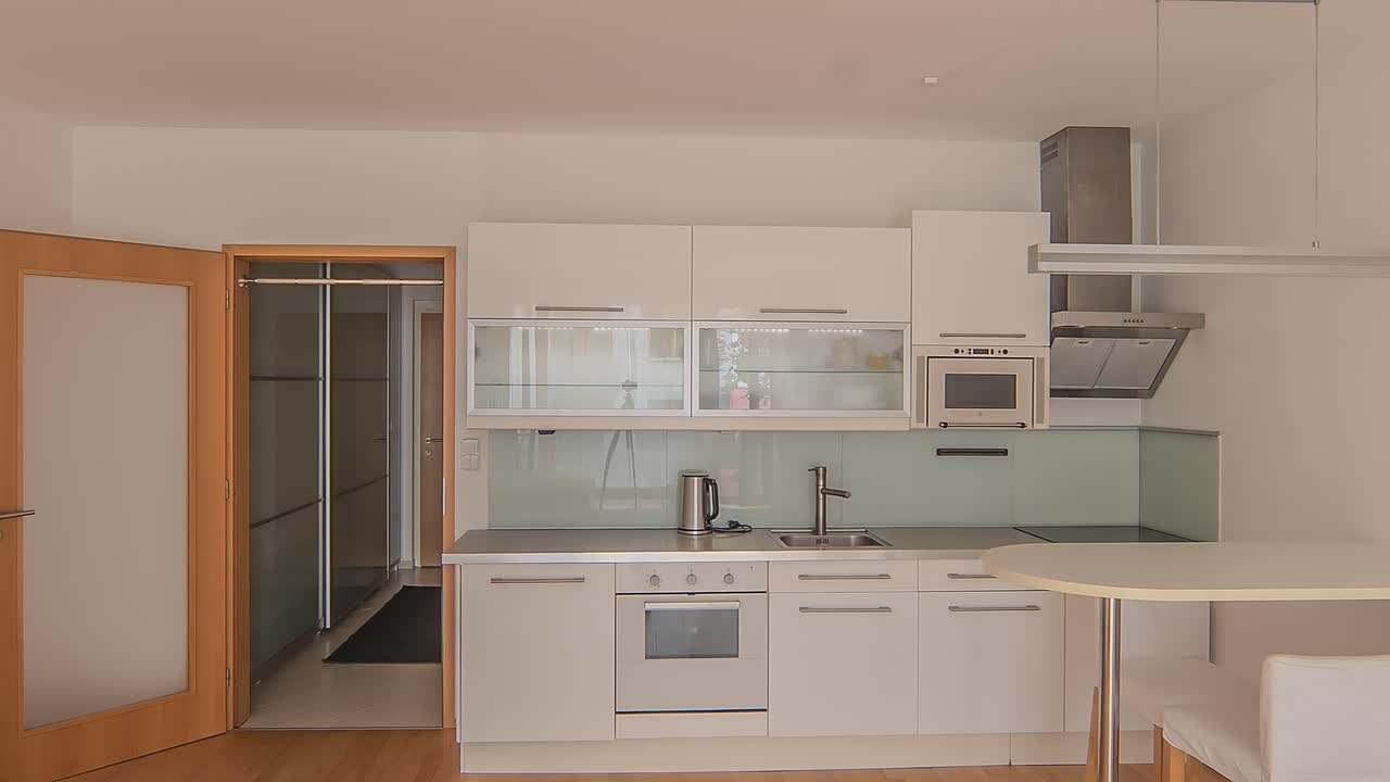 Un monolocale luminoso e spazioso con mobili bianchi eleganti e una cucina moderna.