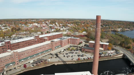 Old-Biddeford-Saco-Mill-buildings-and-famous-smokestack,-aerial-shot