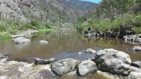 low aerial flight up class iii river rapid in craggy rock canyon