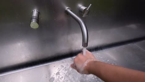 person washing hands under running water