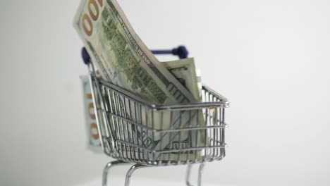 shopping cart loaded with usd 100 bills note rotate on white background e-commerce sale online